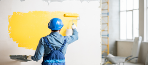 Male painting a wall in an empty business space