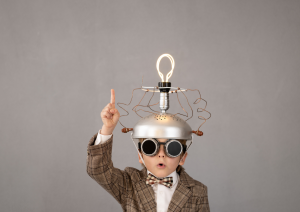 Young boy wearing brain contraption on head depicting a bright idea